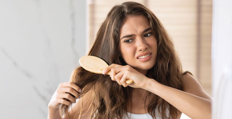 Woman having difficulty brushing hair