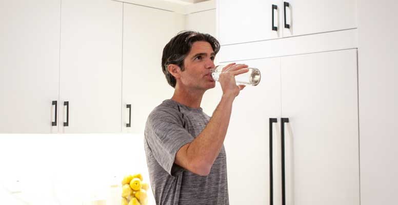 Man drinking water in kitchen