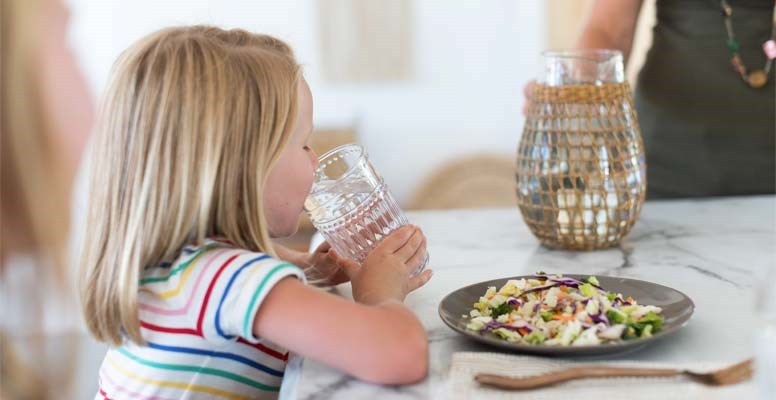 Girl drinking water and eating salad
