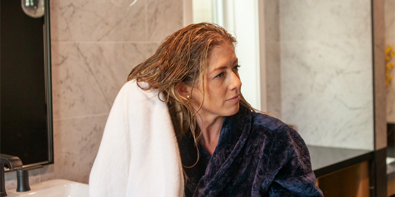 Woman drying hair in a bathroom